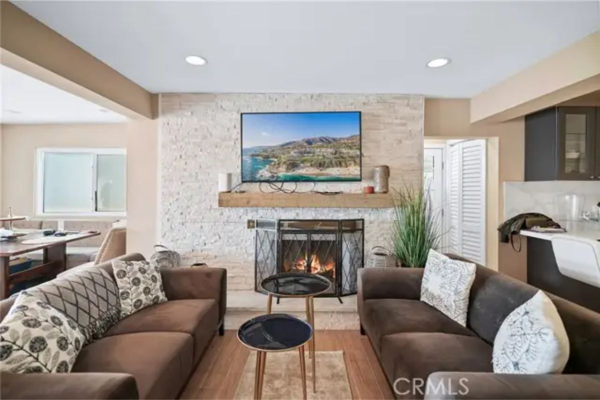 Open living space with two facing loveseats and a central fireplace.