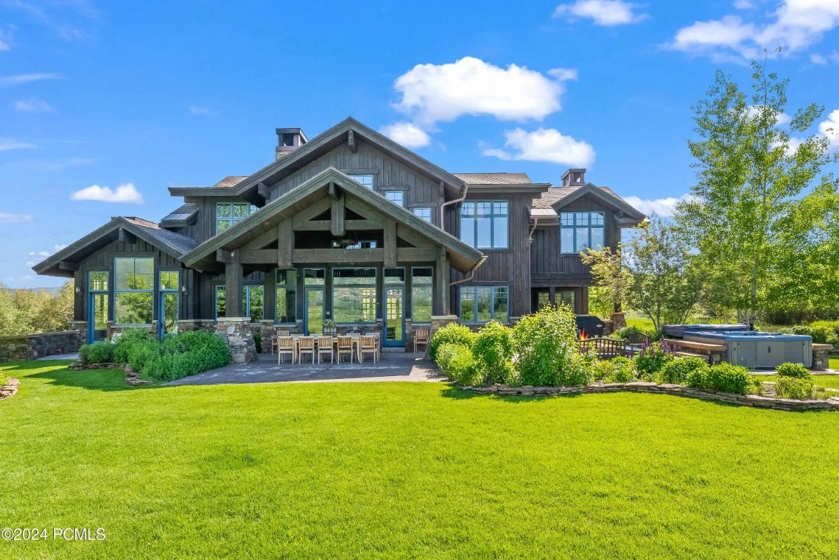 Two-story home with pitched rooflines and exposed beams framing the covered patio.