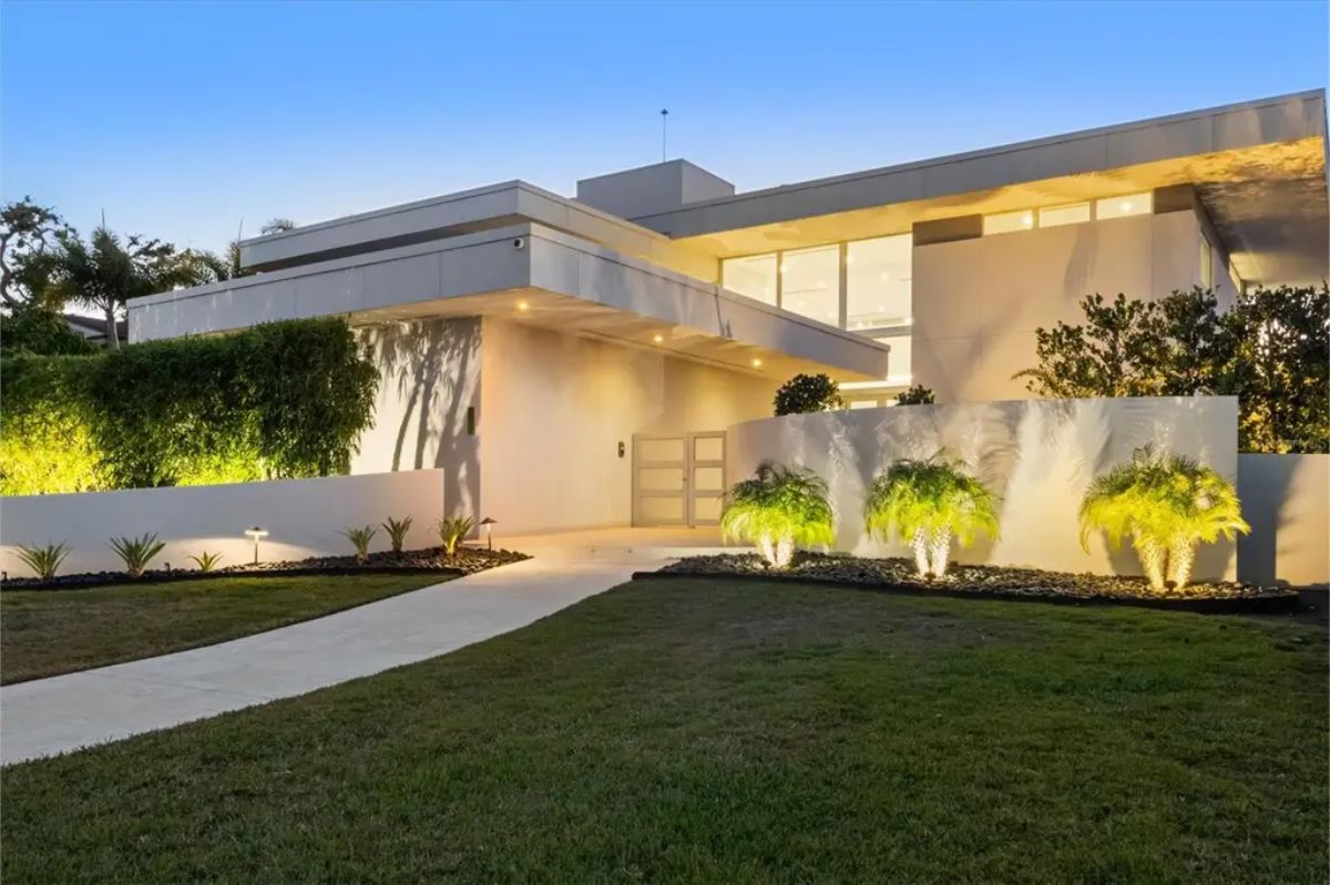 Elegant front entrance with minimalist landscaping, soft lighting, and a clean architectural style. 