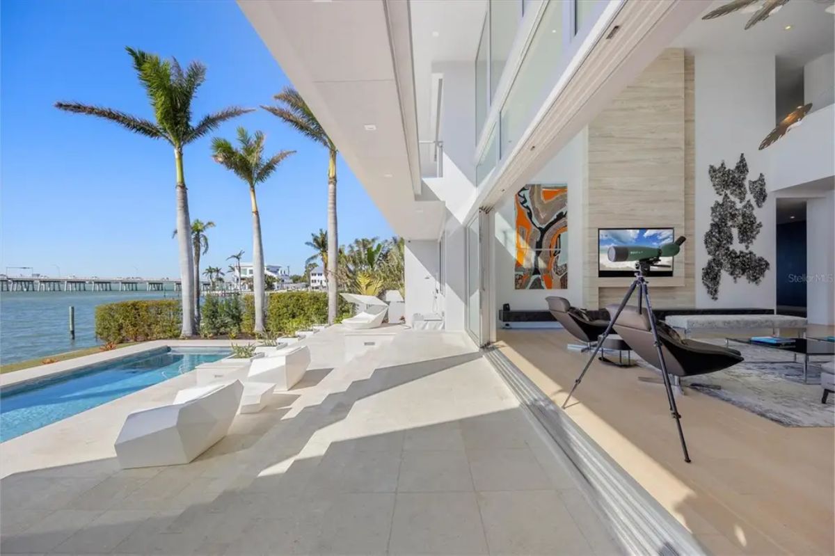Expansive open-air lounge with seamless indoor-outdoor flow, poolside views, and elegant decor. 