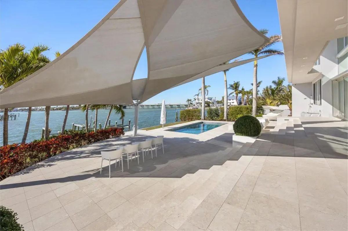 Modern outdoor area with a shaded seating section, sleek landscaping, and a pristine poolside setting. 