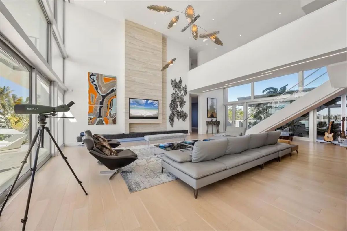 Expansive living room with high ceilings, contemporary furniture, and unique hanging light fixtures. 