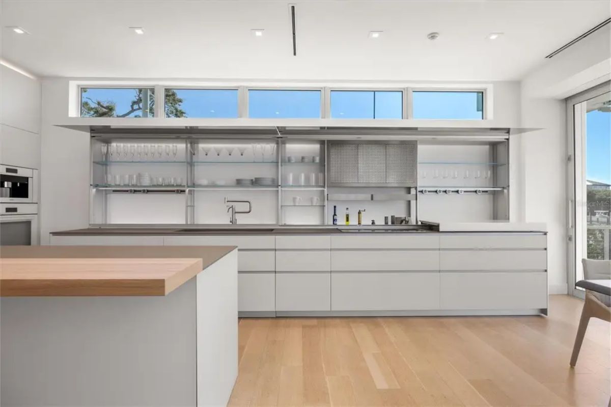 Minimalist kitchen design with sleek countertops, open shelving, and natural light streaming in. 