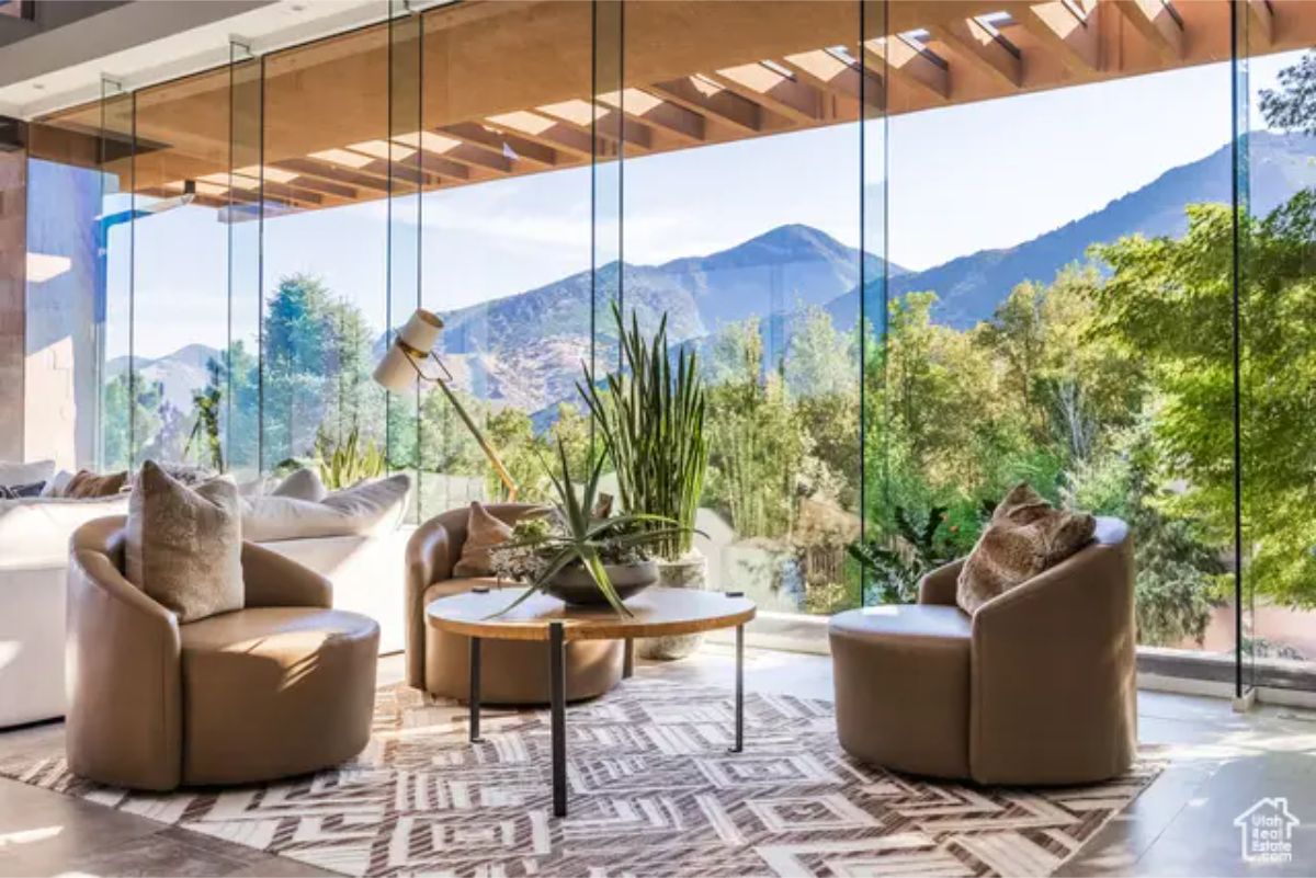Stylish lounge area with curved glass walls, allowing a breathtaking mountain landscape view. 