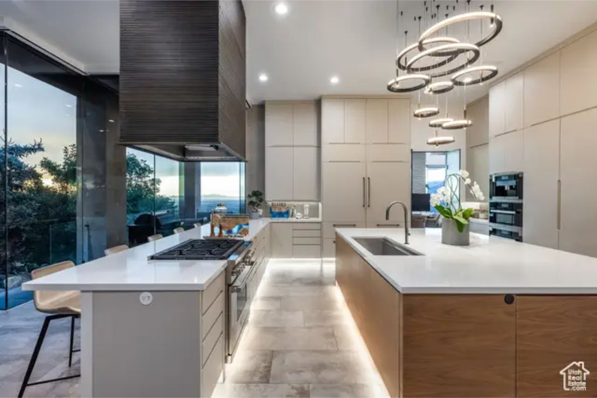 Another perspective of the kitchen, showcasing dual islands, pendant lights, and a seamless transition to outdoor spaces. 