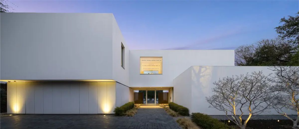 Sleek, geometric facade featuring a large glass window and an inviting entrance. 