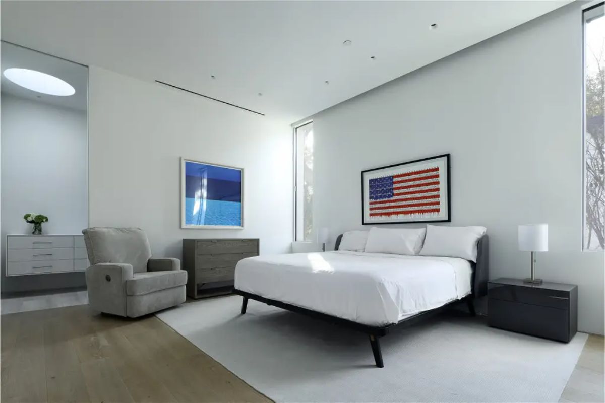 A bedroom featuring a large American flag artwork, neutral furnishings, and a contemporary aesthetic. 
