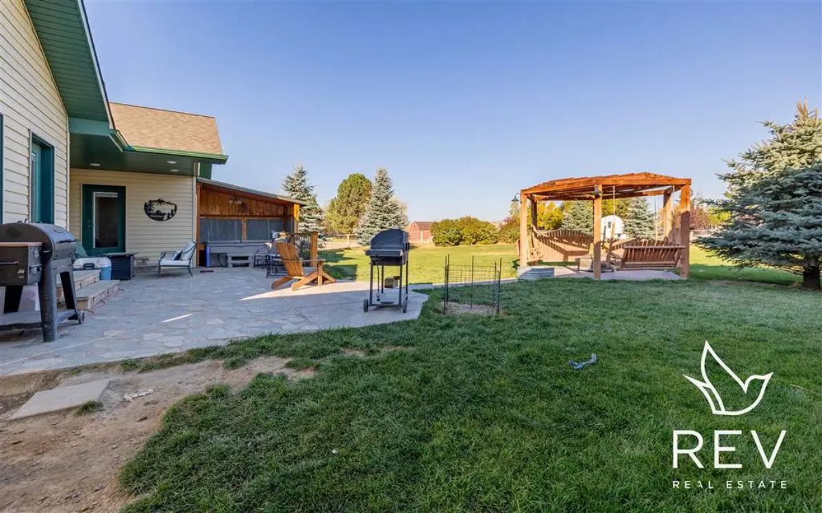 Stone patio extends from the house with multiple grills.