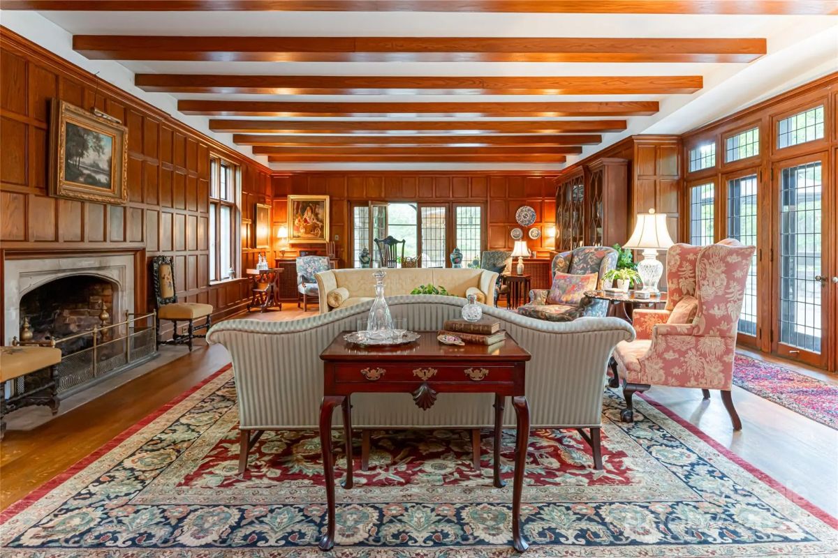 Exposed ceiling beams run the length of the room above wood-paneled walls.