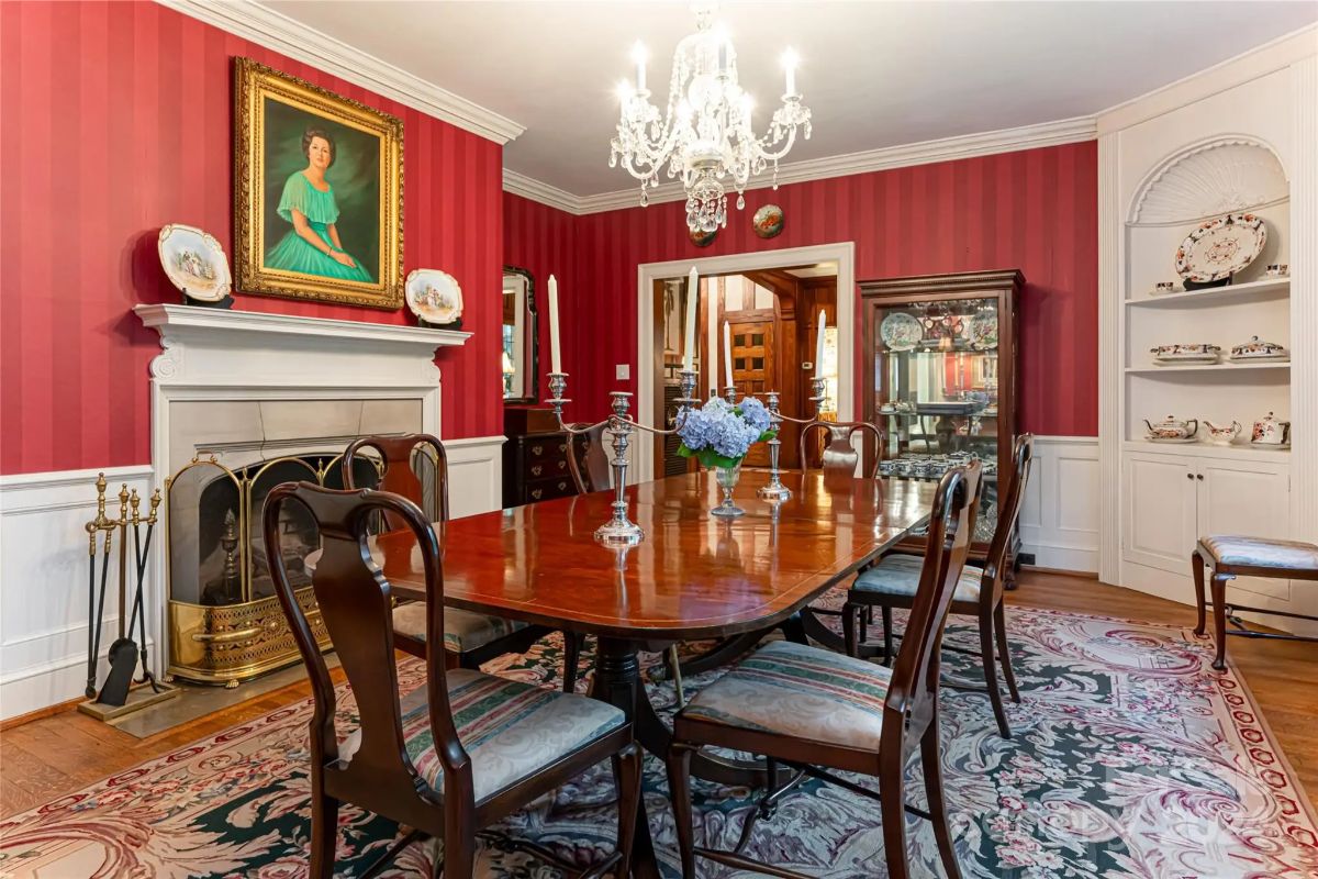 Large wooden dining table is centered beneath a crystal chandelier.