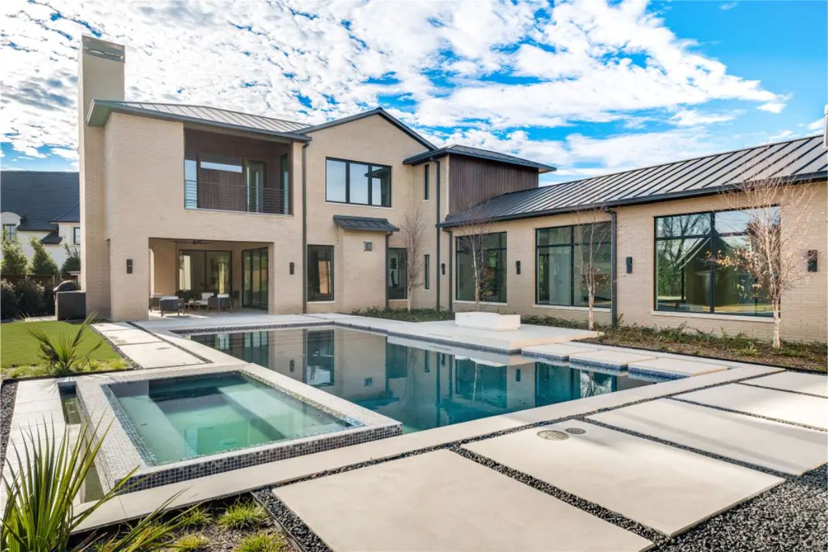 Stunning backyard featuring a modern pool, spa, and a combination of hardscape and greenery. 