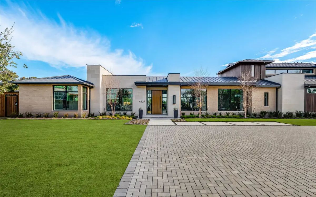 Closer view of the house’s entrance, featuring a mix of stone and wood accents with a sleek, contemporary design. 