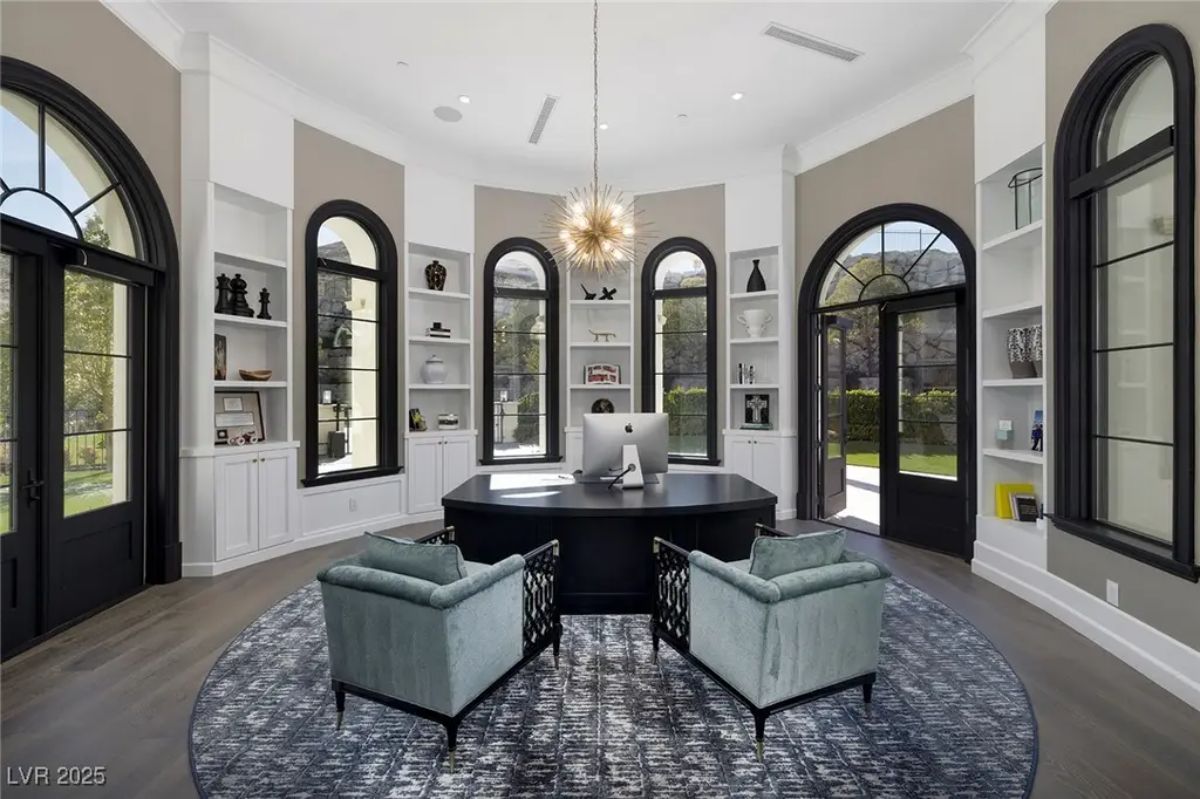 Spacious office with dark executive desk is positioned on a circular rug.