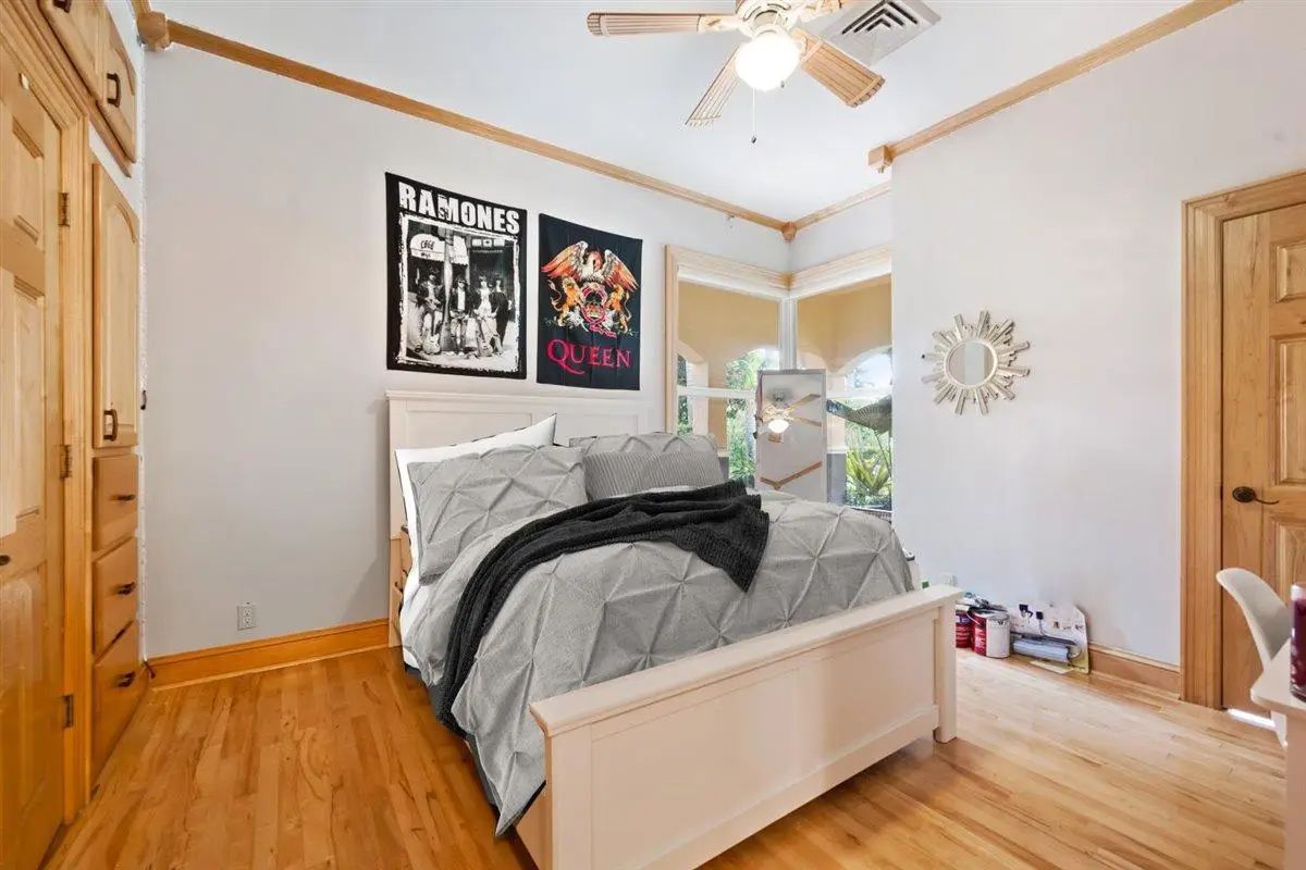 Bedroom with hardwood flooring and white-painted walls.