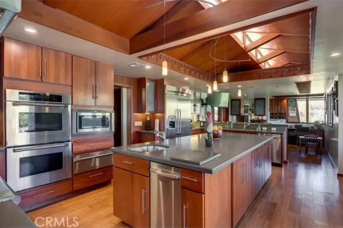 Kitchen features dark countertops, stainless appliances,