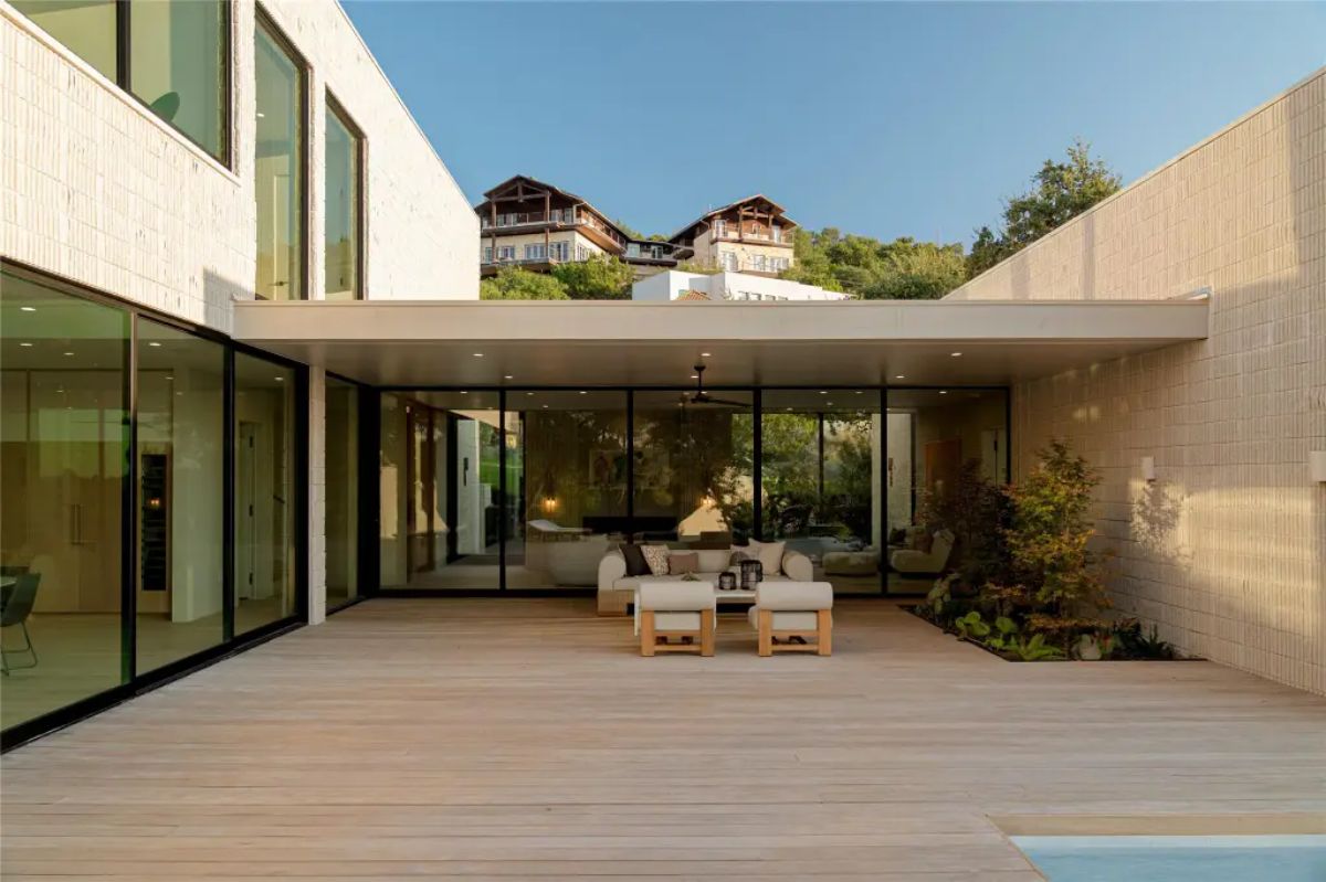 Inviting outdoor courtyard with a wooden deck, cozy seating, and seamless connectivity to indoor living spaces. 