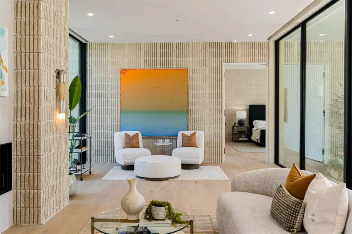 Bright and airy sitting area with a bold gradient painting, stylish chairs, and floor-to-ceiling windows. 