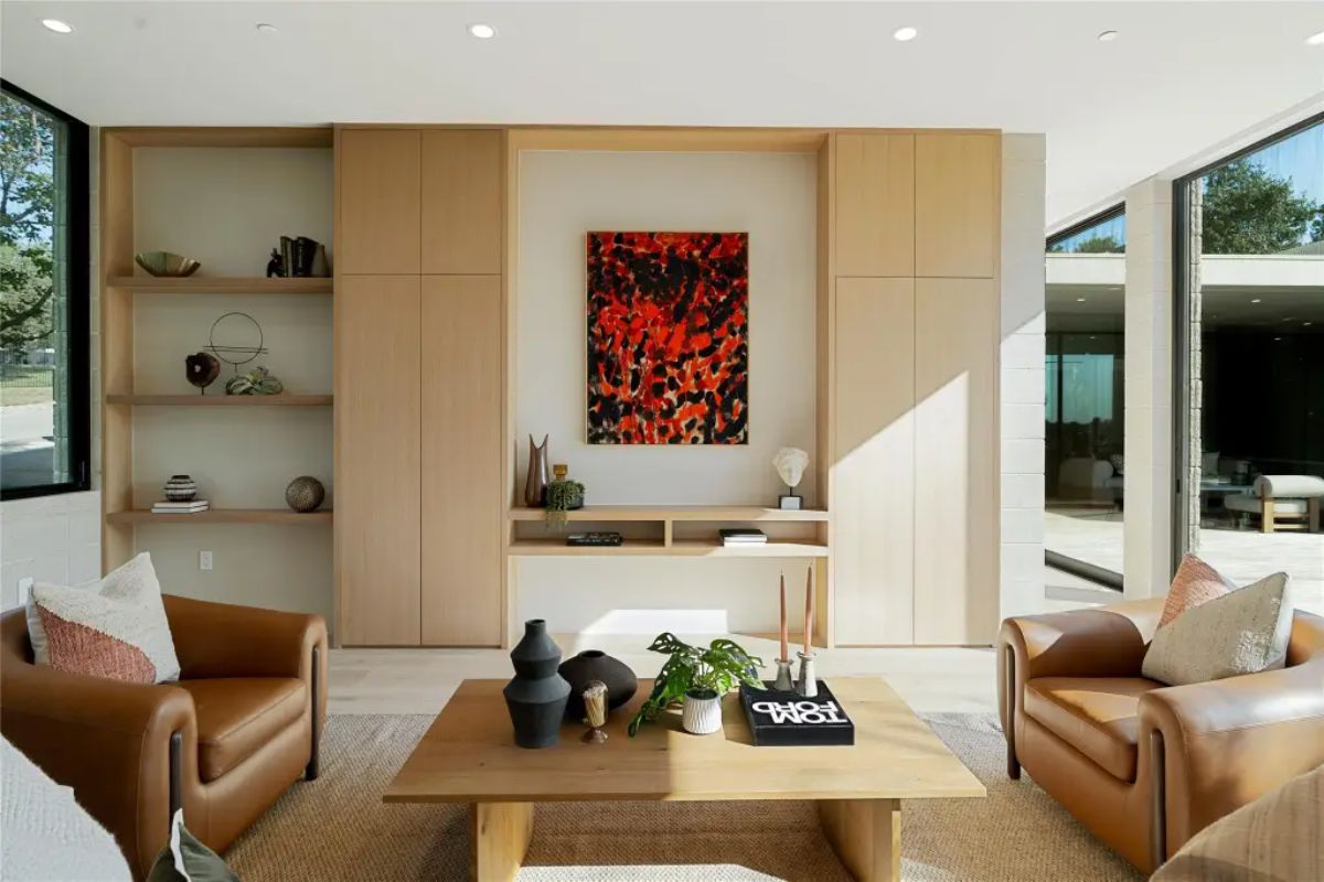 Chic and inviting lounge space with leather armchairs, a wooden coffee table, and built-in shelving. 