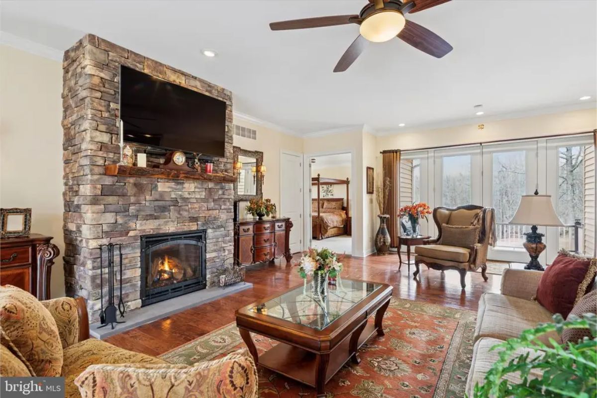 Stone fireplace serves as the focal point of the living room, with a mounted television above.