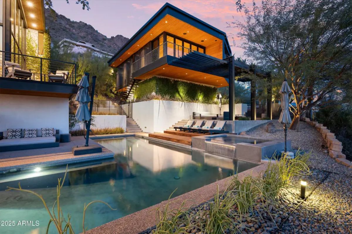 Nighttime view of the home's striking architecture, showcasing tiered levels, ambient lighting, and a serene poolside retreat. 