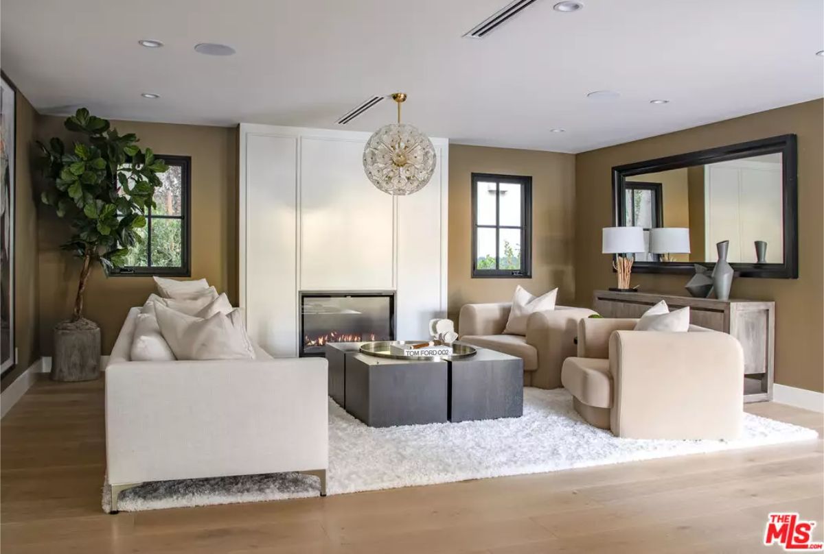Seating is arranged around a square coffee table and a sleek built-in fireplace.