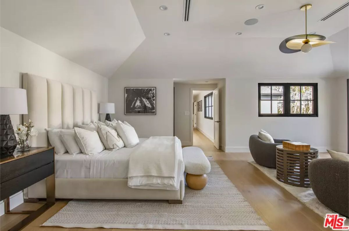 A tall upholstered headboard extends nearly to the angled ceiling.