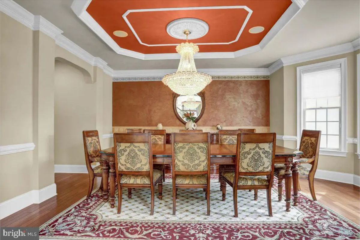 Dining room with a tray ceiling and an ornate chandelier.