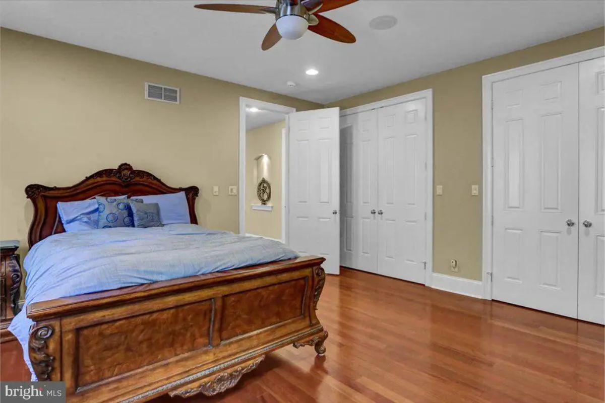 Cozy bedroom featuring a carved wooden bed frame and matching furniture.