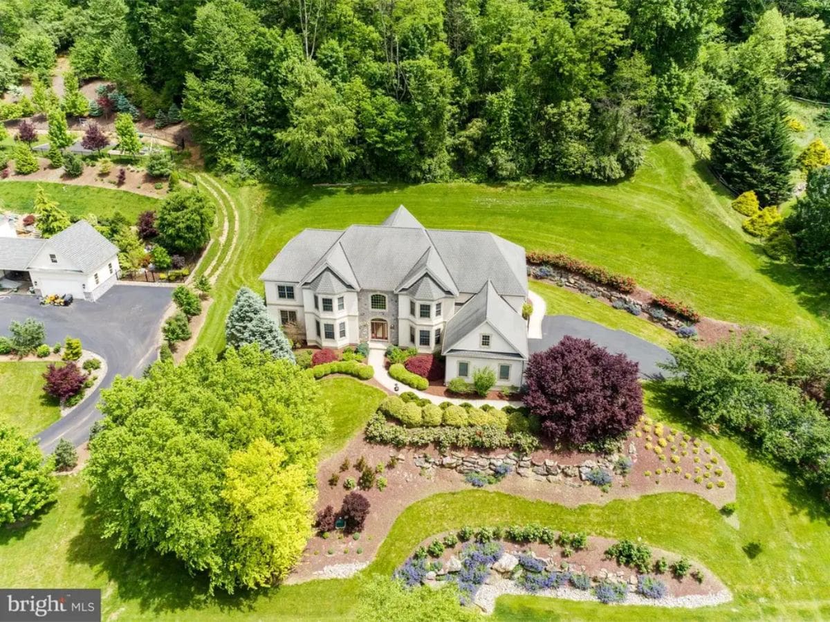 Expansive estate surrounded by lush greenery and landscaped gardens.