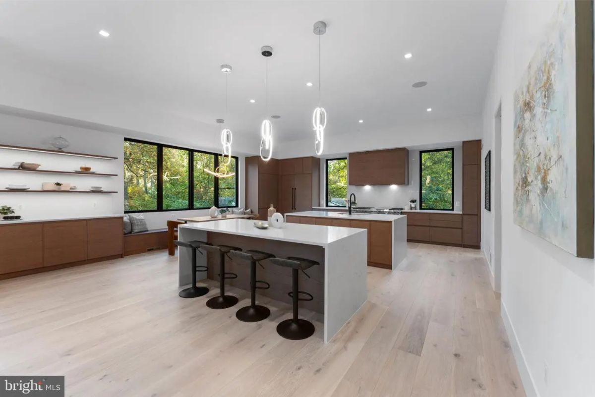 Spacious modern kitchen with dual islands, pendant lighting, and floor-to-ceiling windows. 
