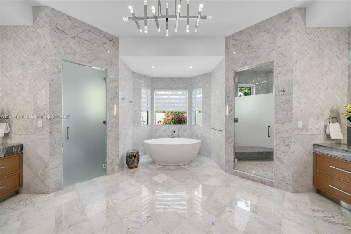 Freestanding tub is centered in front of a bay window.