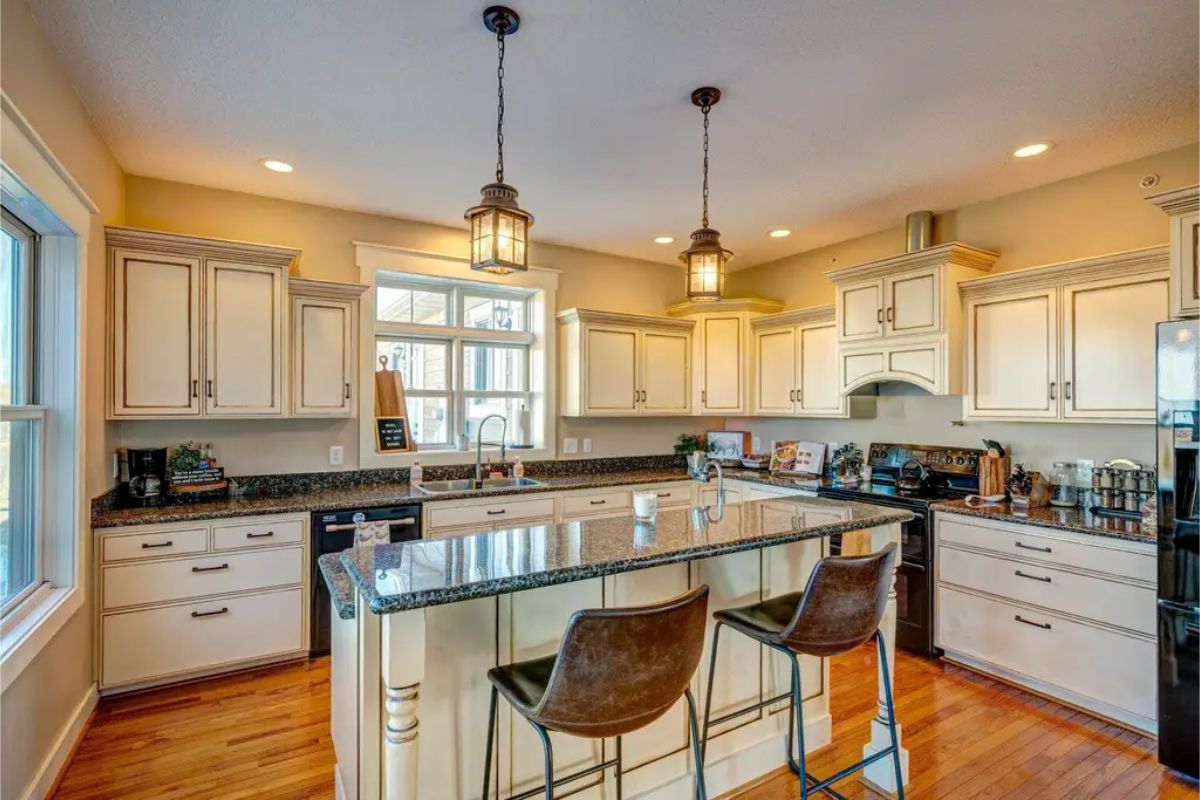 White cabinetry with black granite countertops creates a classic contrast.