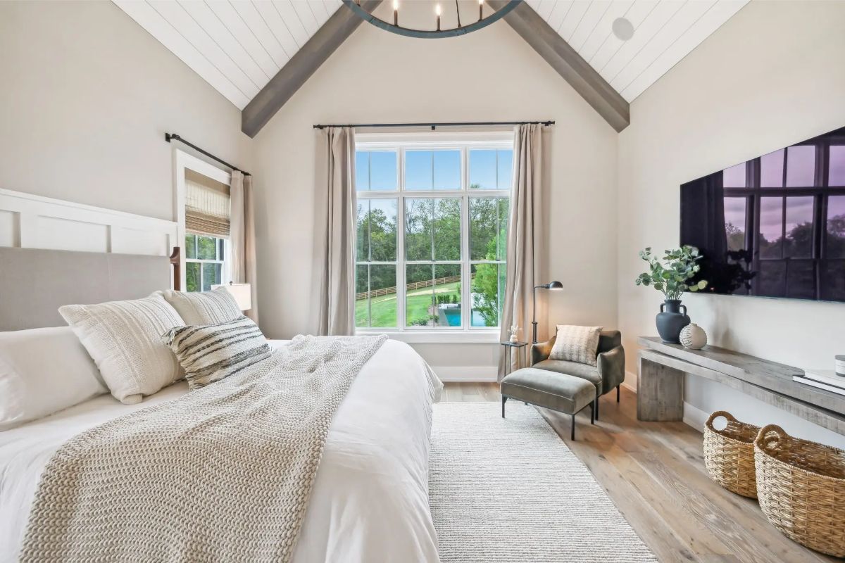 Alternate view of the primary bedroom featuring cozy decor, reading nook, and TV wall. 