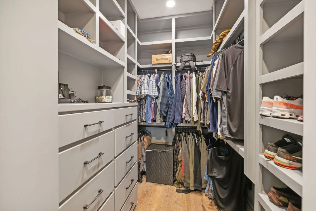 Custom walk-in closet with built-in drawers, shelves, and organized hanging space. 