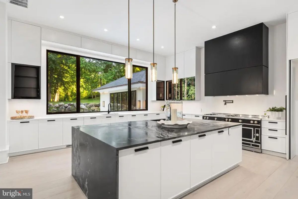 White cabinetry and black marble countertops create a modern contrast.