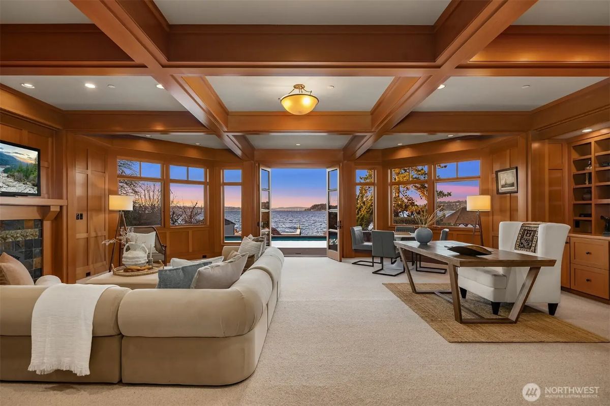 Spacious multi-use room with office and lounge areas, opening directly to the outdoor pool and waterfront. 