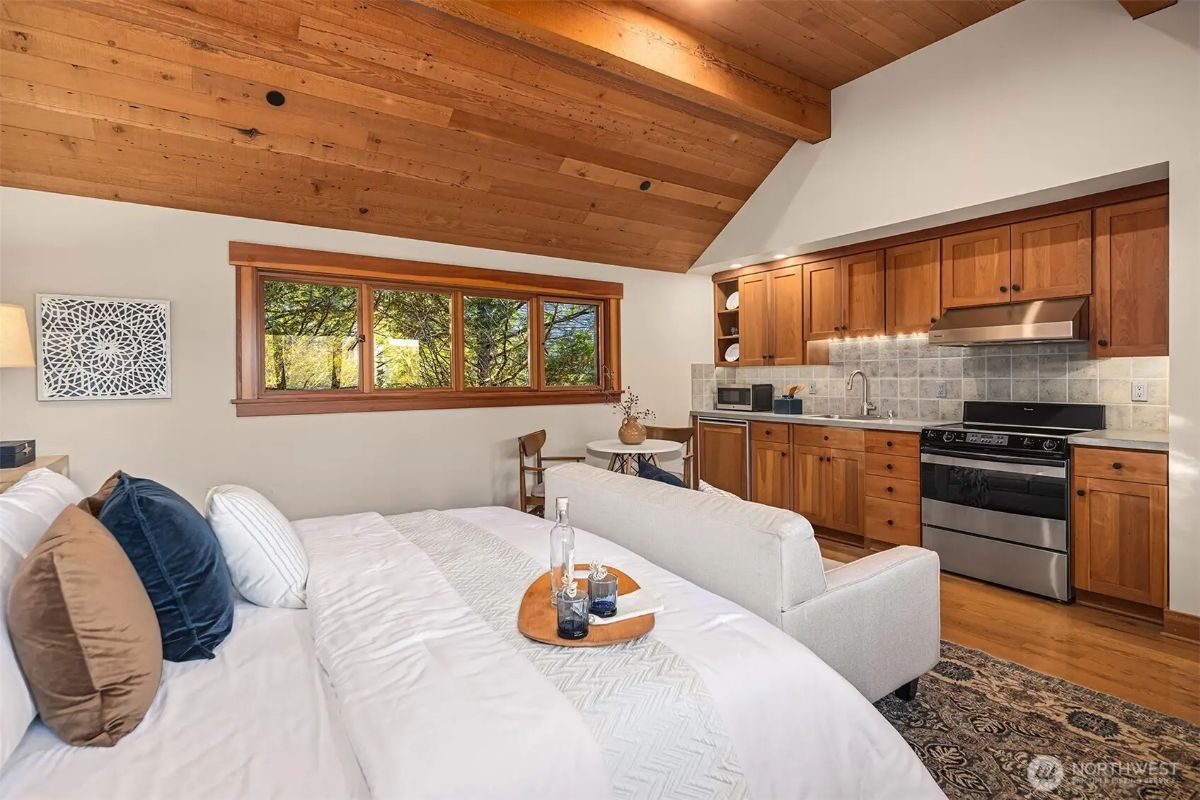 Cozy guest suite featuring a kitchenette, vaulted ceilings, and a warm mix of wood finishes. 