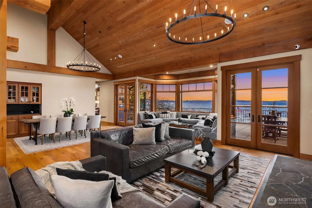 Open-concept living and dining space with vaulted wood ceilings, modern chandeliers, and seamless indoor-outdoor flow. 
