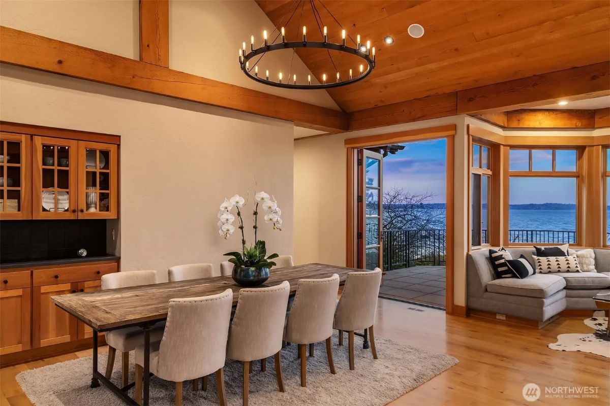 Elegant dining room with plush seating and access to the deck, ideal for entertaining with a view. 