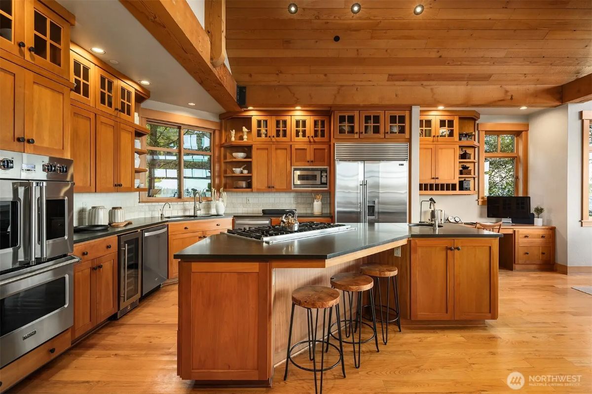 Gourmet kitchen with rich wood cabinetry, high-end appliances, and a central island with bar seating. 