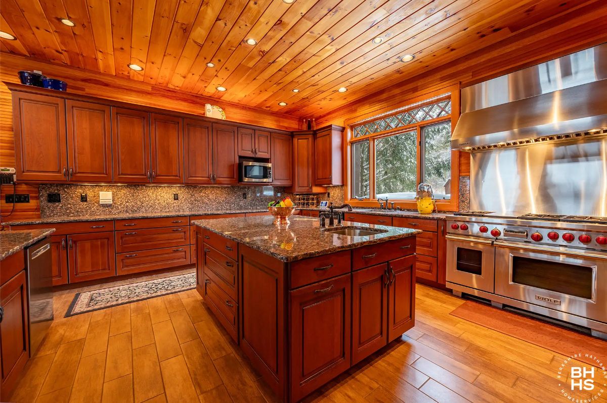 Wraparound wood cabinetry and granite countertops define the large kitchen layout.