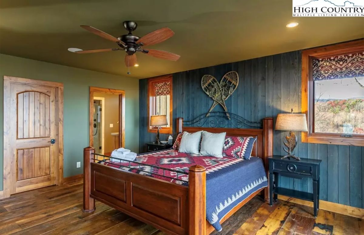 Wood flooring and trim contrast with dark painted walls and a paneled accent wall.