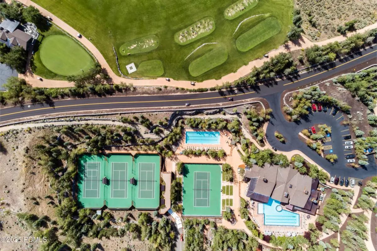 Sports and recreation complex with tennis courts, swimming pools, a golf course, and surrounding nature. 