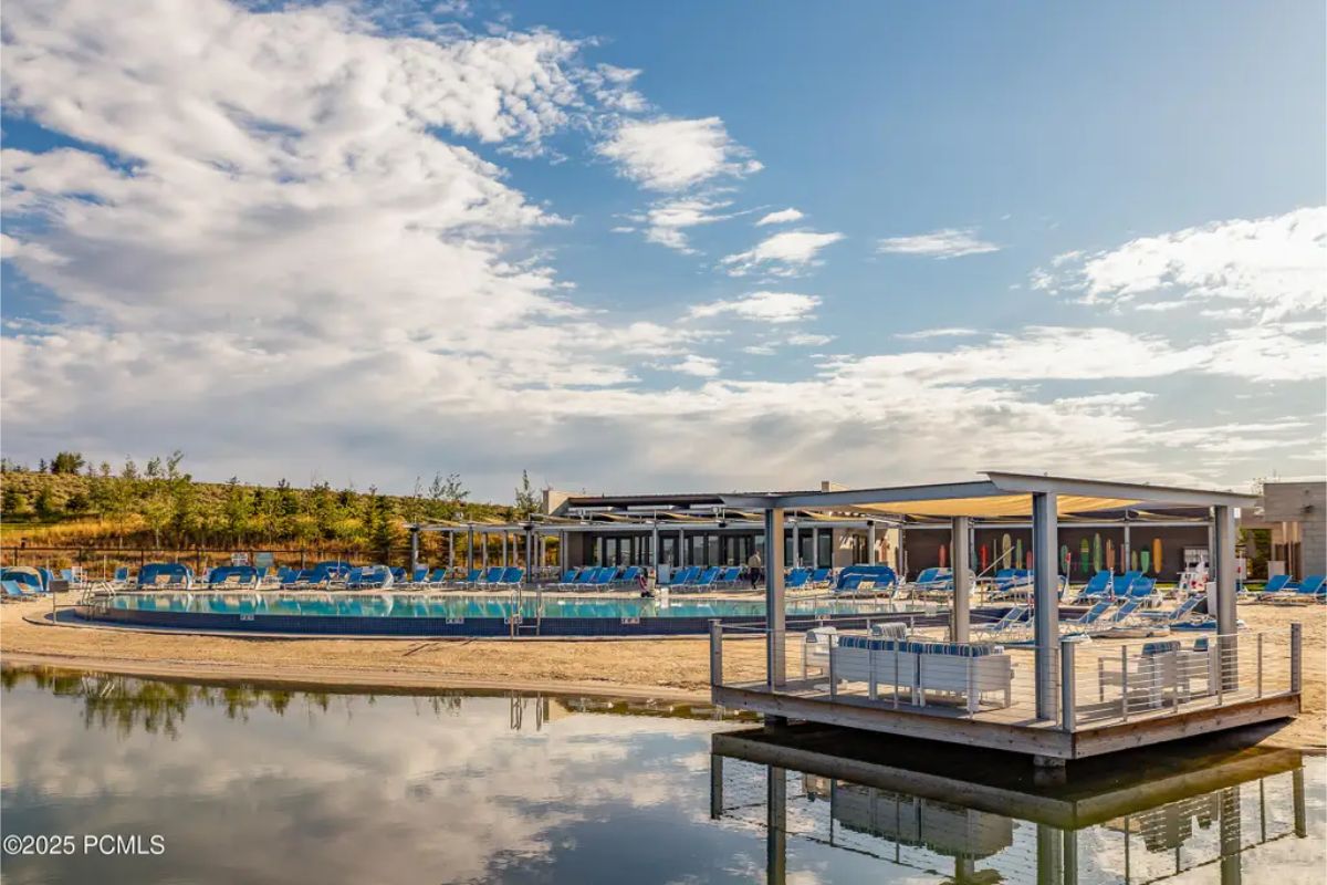 Resort-style outdoor space with a private beach, a floating dock, and cabanas by the water. 