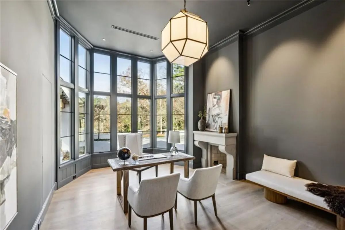 Sophisticated study with moody gray walls and striking architectural windows. 