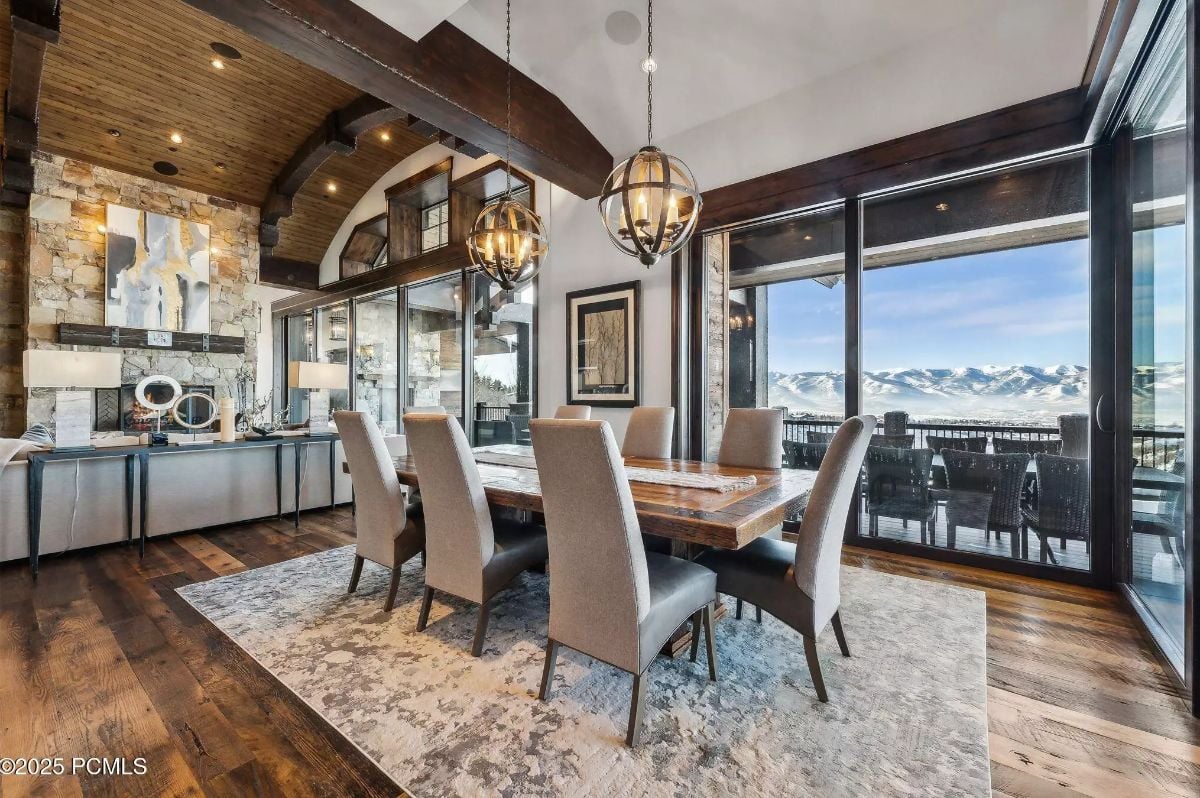 Dining area positioned next to large windows with sweeping views of a mountain range.
