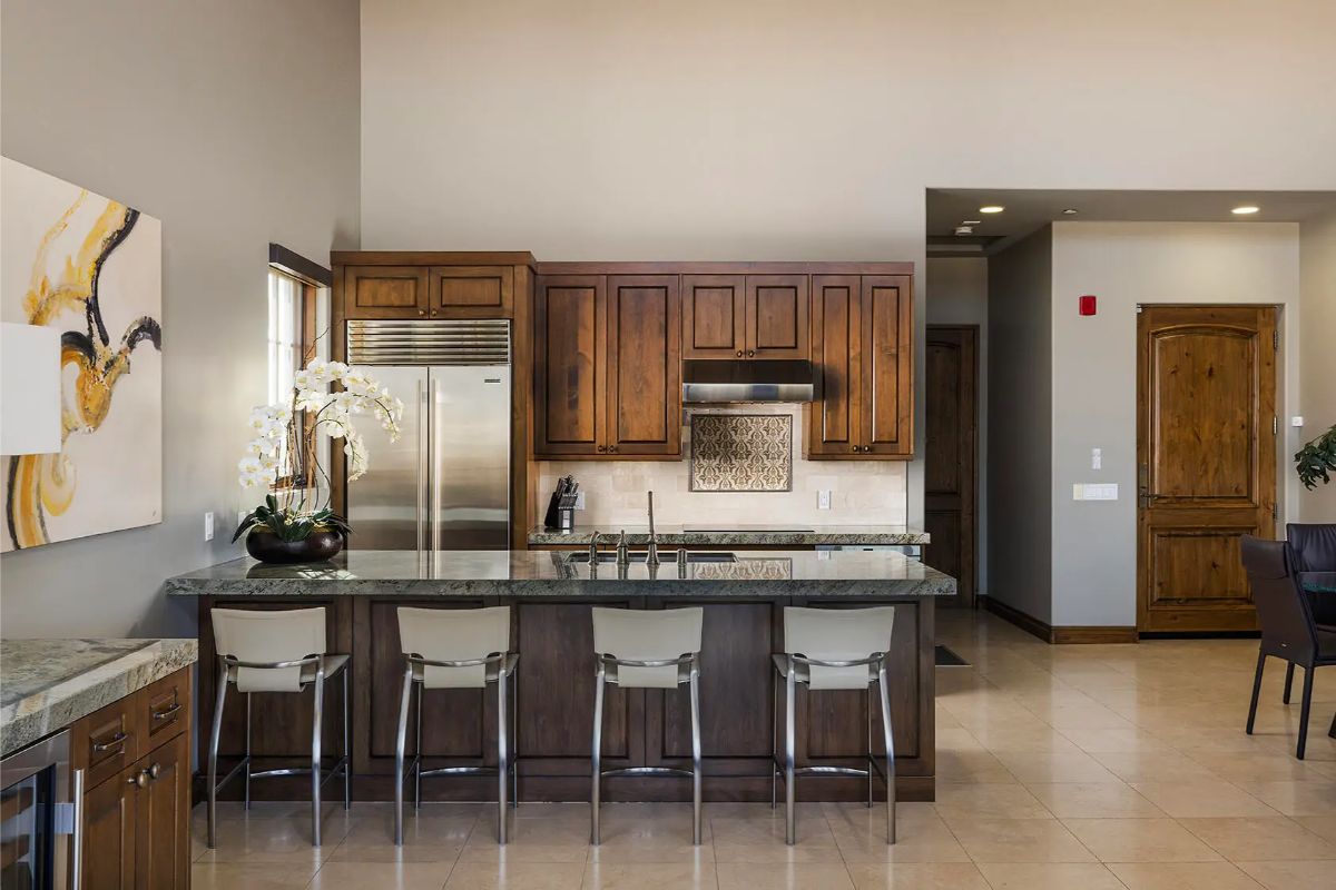 Wood cabinetry contrasts with granite countertops and stainless steel appliances.
