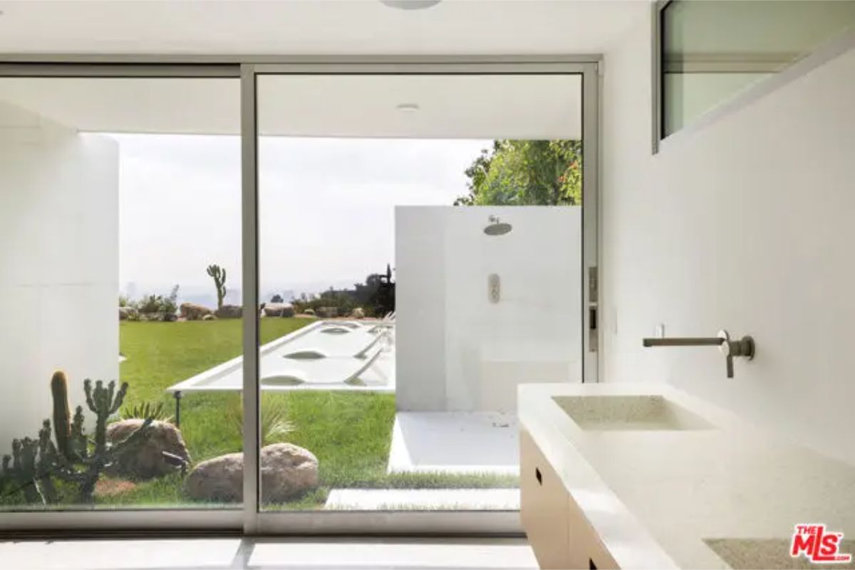 Bright bathroom with a glass shower, clean lines, and a direct view of the outdoor relaxation area. 