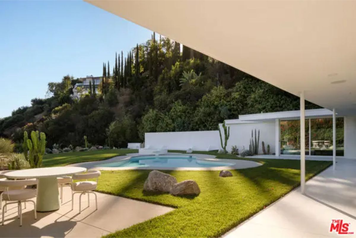 Covered outdoor dining area with a breathtaking hillside view and a connection to the pool. 