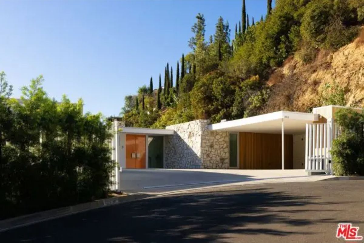 Unique stone and wood facade blending into the hillside with a minimalist architectural style. 